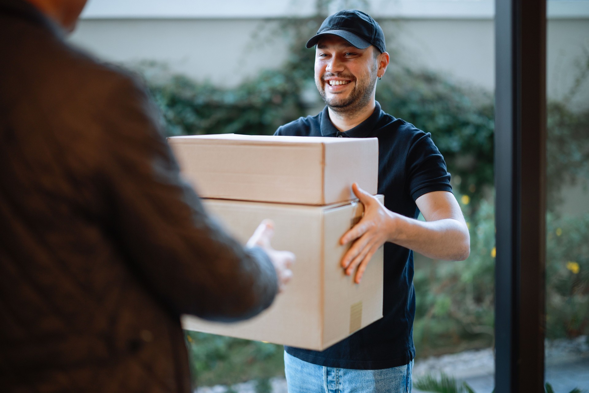 Close up of hands cargo staff are delivering cardboard boxes with parcels inside to the recipient's hand.